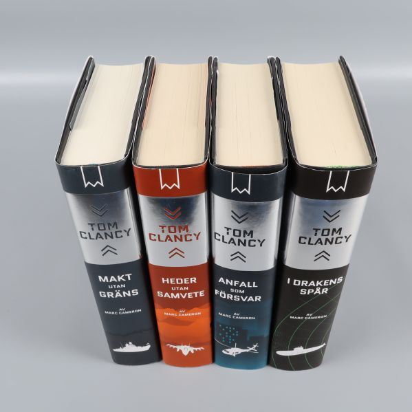 Överblick ovanifrån av fyra Tom Clancy-böcker placerade tätt ihop
