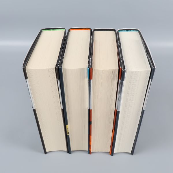 Fyra Tom Clancy-böcker fotade ovanifrån med synliga bladkanter