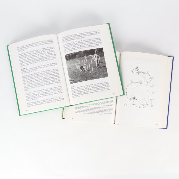 Uppslagna agilityböcker med instruktionstexter, skisser och foton