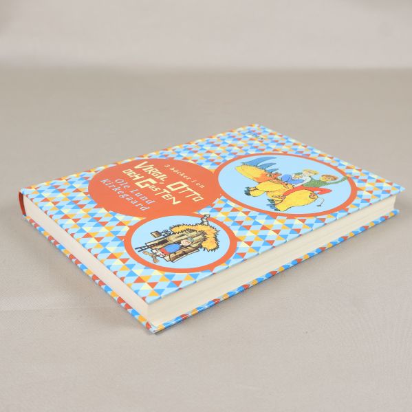 Boken från ovan i vinkel, visar pärmens mönster och illustrationer