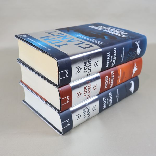 Tre Tom Clancy-böcker staplade på varandra, snett ovanifrån