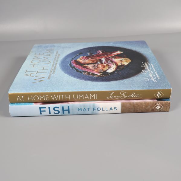 Två kokböcker staplade där ryggarna visar titlarna At Home With Umami och Fish