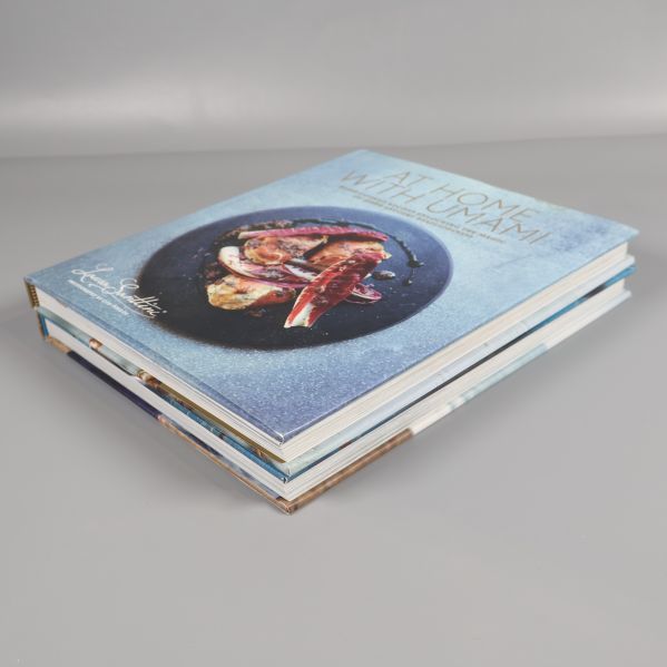 Kokböcker staplade snett ovanifrån, tydligt omslag på At Home With Umami överst