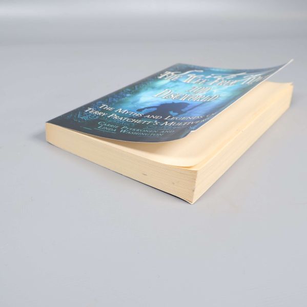 Boken liggande med synliga sidor och mjukpärm