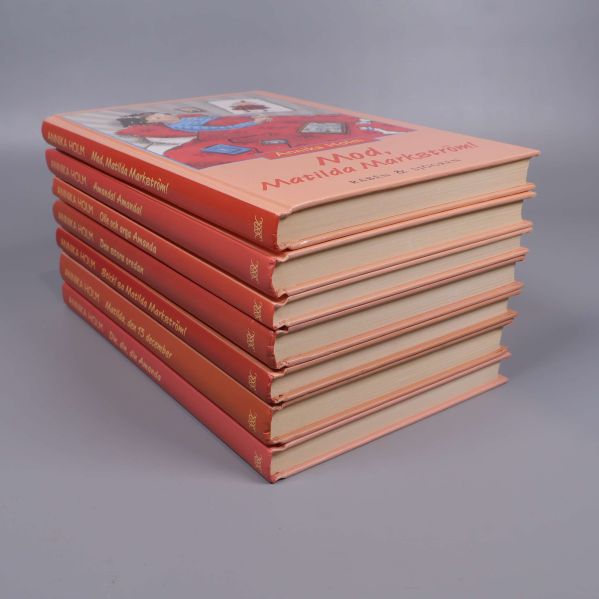 Snedställt perspektiv av bokpaketet med viss kantnötning på omslagen