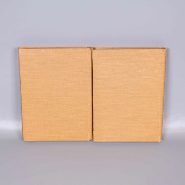 Baksida på två inbundna böcker i ljusbrunt tygband utan tryck