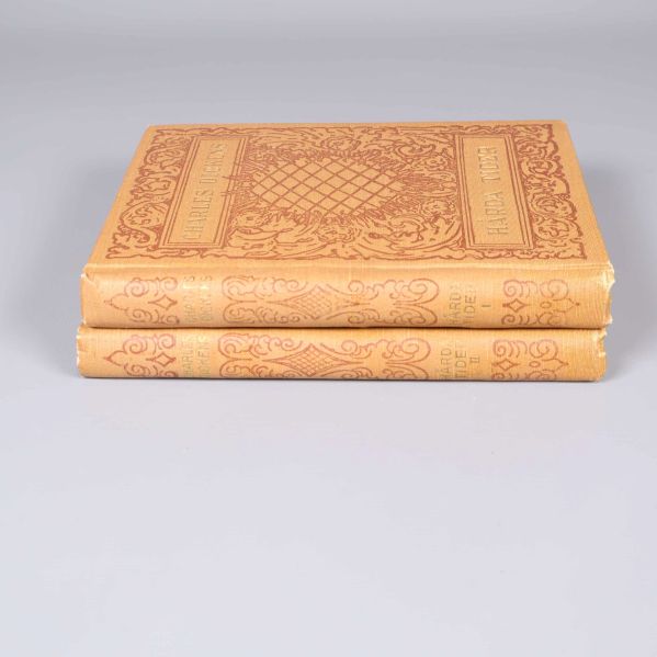 Två böcker staplade, visar rygg med titlar och dekor