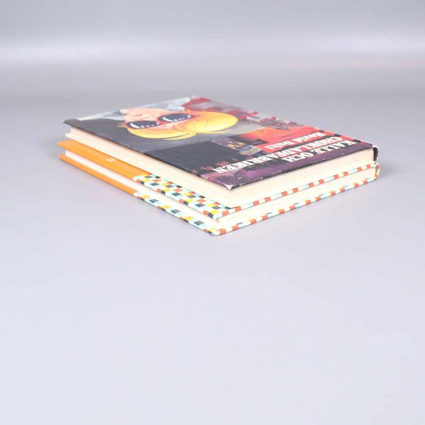 Två inbundna barnböcker staplade i vinkel på bord