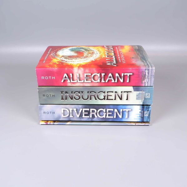 Tre böcker ur Divergent-serien liggande i stapel med titlar synliga