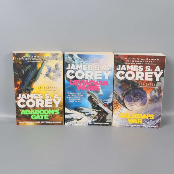 Tre böcker ur The Expanse-serien stående sida vid sida