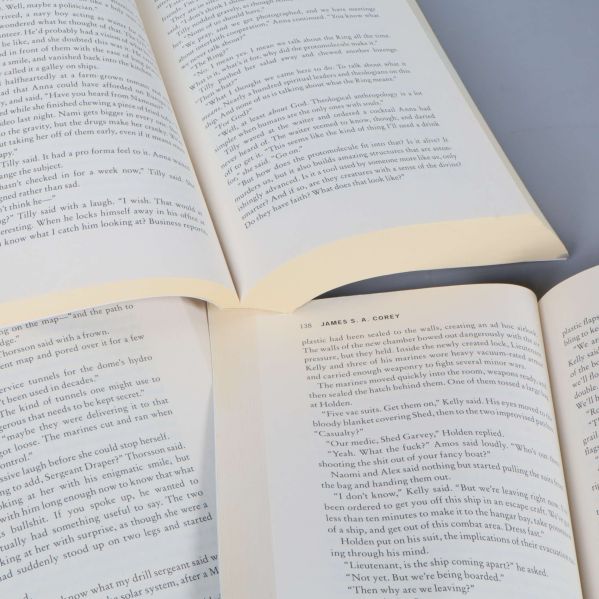 Uppslagna sidor ur de tre böckerna med engelsk text