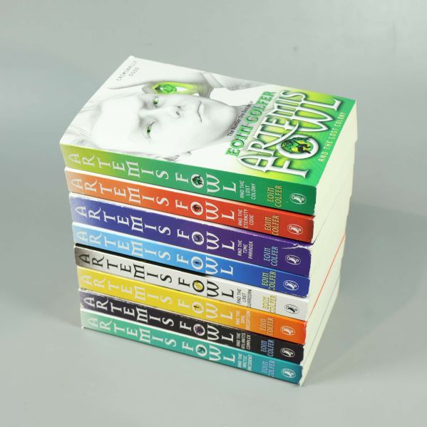 Staplad hög av åtta Artemis Fowl-böcker med färgglada ryggar