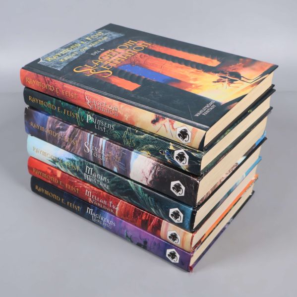 Böcker ur Kriget om rämnan staplade med ryggarna synliga