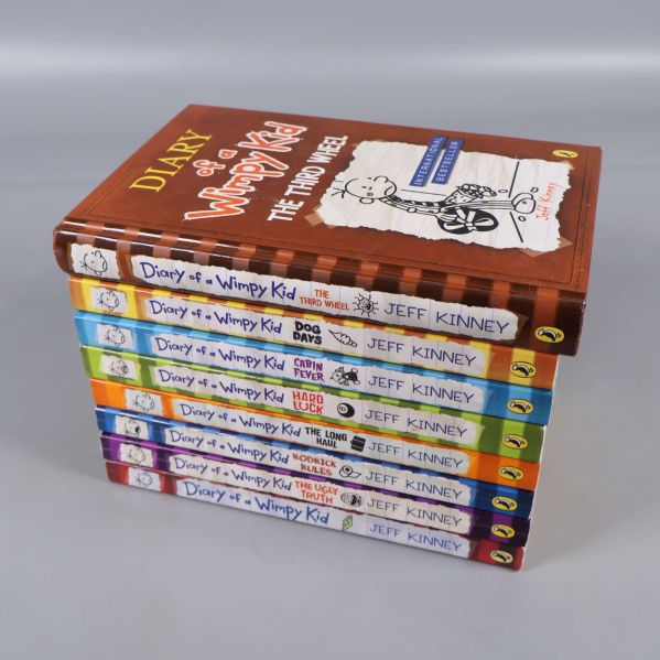 Åtta böcker ur Diary of a Wimpy Kid-serien staplade i färgglad ordning