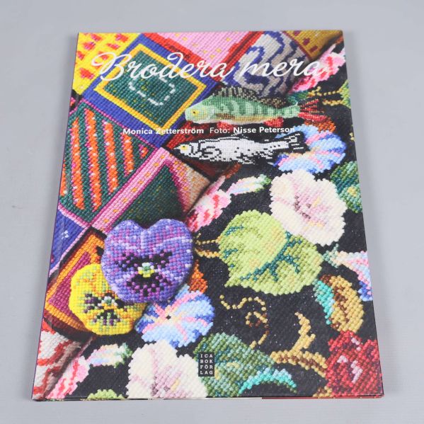 Framsida av boken Brodera mera med färgstarkt broderimotiv