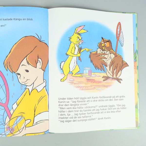 Uppslag ur Nalle Puh bok med färgglada illustrationer och svensk text