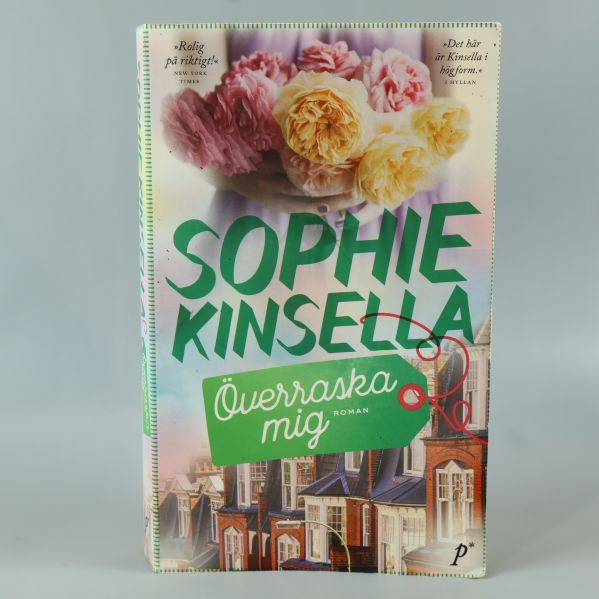 Omslag på boken Överraska mig av Sophie Kinsella med blommor och grönt textfält