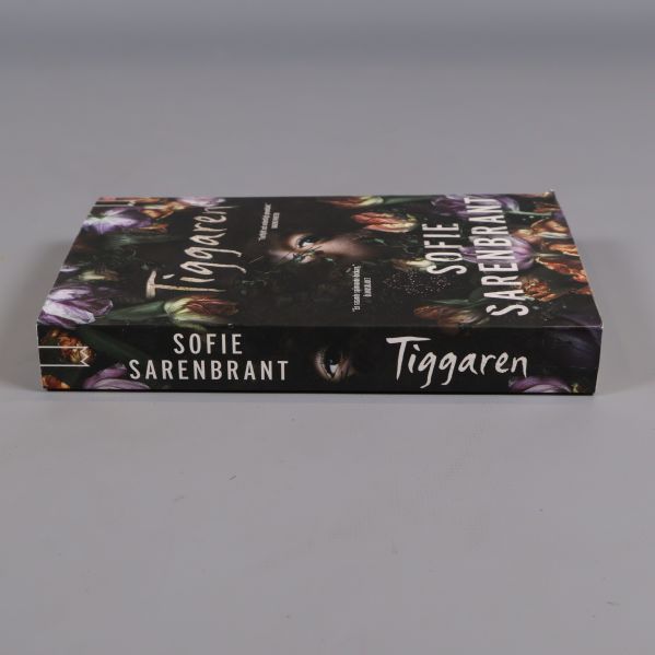 Boken Tiggaren liggande med synlig rygg och omslag