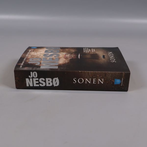 Sonen av Jo Nesbø sedd från sidan med bokrygg synlig