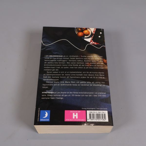 Baksidan av boken Hypnotisören med textbeskrivning och synlig ISBN-kod