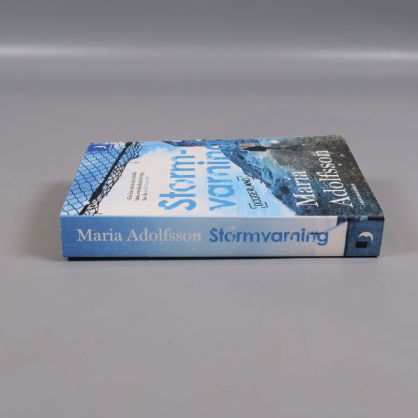 Boken Stormvarning liggande med synlig rygg och titel