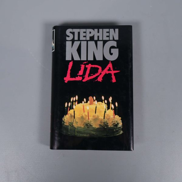 Framsidan av boken Lida av Stephen King med tårta och ljus