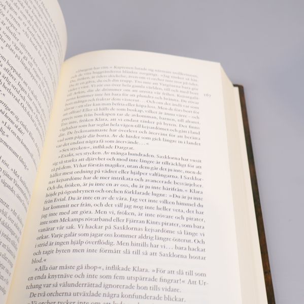 Uppslag i boken med svensk text på ena sidan