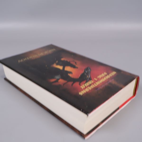 Boken liggande med synlig sida och omslagets framsida