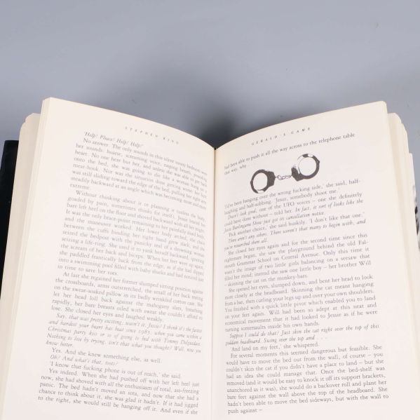 Uppslag ur Gerald's Game, engelskspråkig text och illustration av handklovar