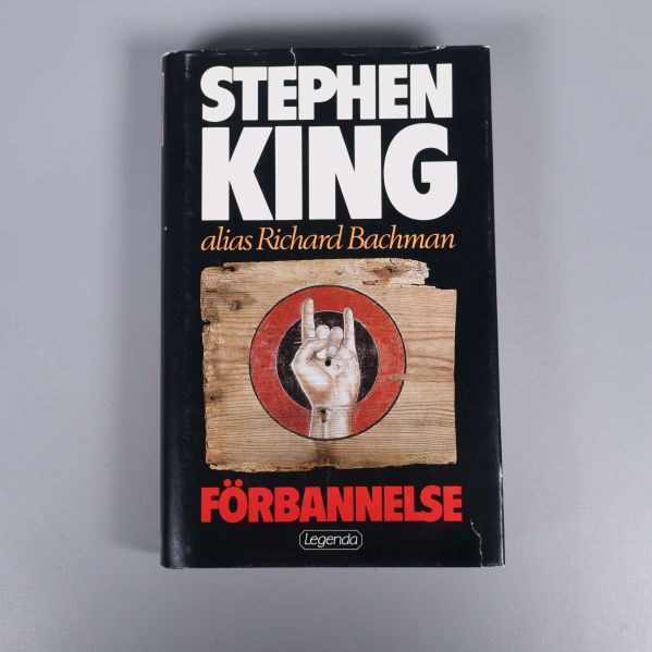 Omslag på Förbannelse av Stephen King, svart bakgrund och handsymbol