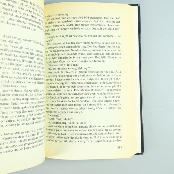 Närbild av ett uppslag i Cujo med svensk text på sidorna