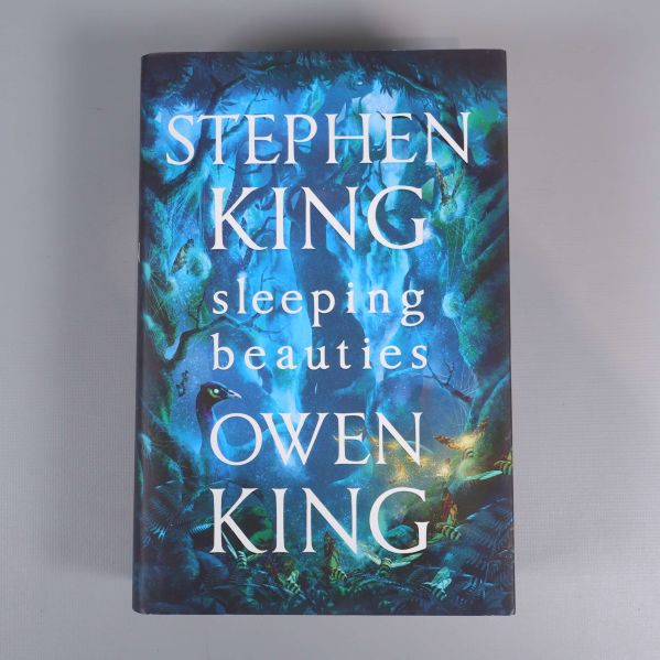 Omslag av boken Sleeping beauties av Stephen och Owen King, blått skogsmotiv