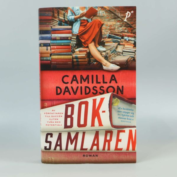 Framsidan av Boksamlaren av Camilla Davidsson, färgstark design med böcker och person