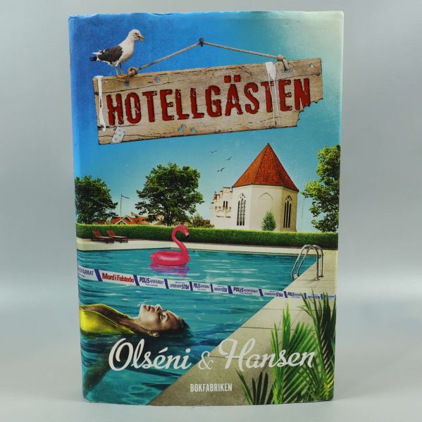 Framsida av boken Hotellgästen med pool, kyrka och rosa flamingo