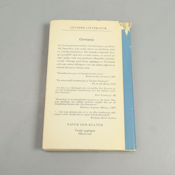 Baksidan av boken Germania, text och blå kant med viss slitage