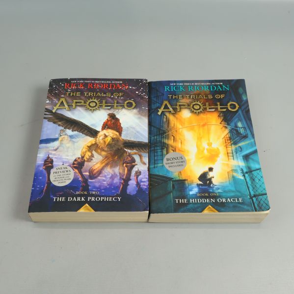 Två böcker ur The Trials of Apollo-serien med färgstarka omslag sida vid sida