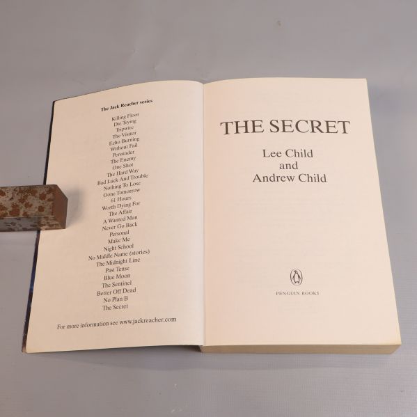 Uppslagen bok med titelsida som visar The Secret och författarnamn