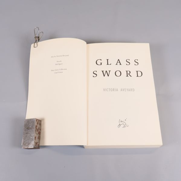 Inslaget uppslag och titelsida till boken Glass Sword av Victoria Aveyard