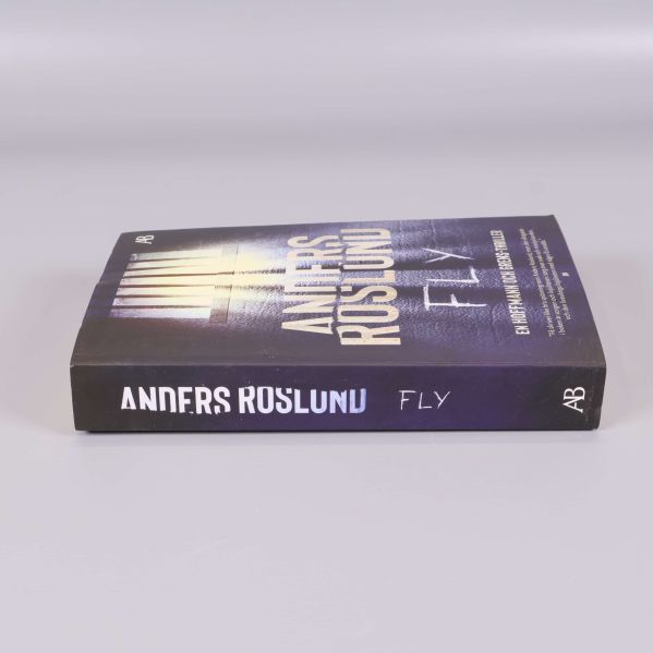 Fly av Anders Roslund liggande med rygg och titel synliga