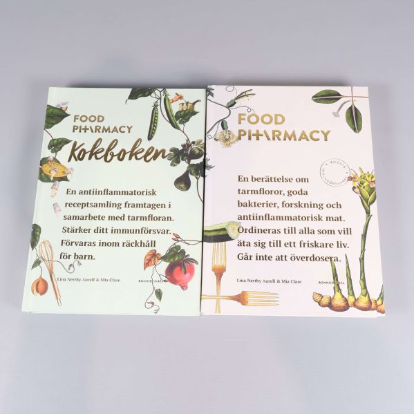 Två böcker Food Pharmacy och kokboken upplagda sida vid sida