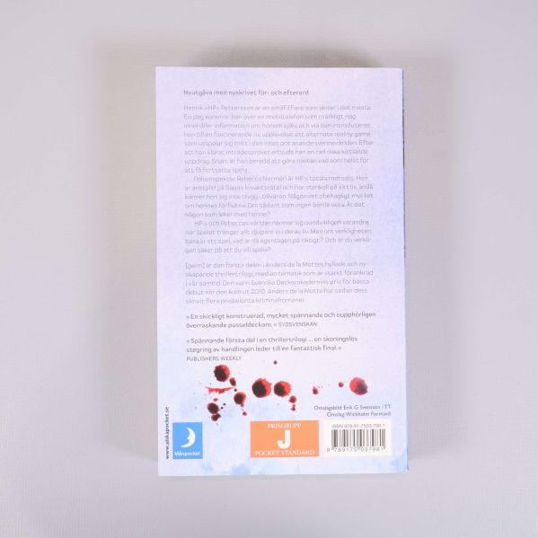 Baksida av Geim med text, recensioner och blodfläckar som designelement