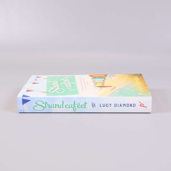 Bokrygg med texten Strandcaféet och Lucy Diamond i grönt och blått