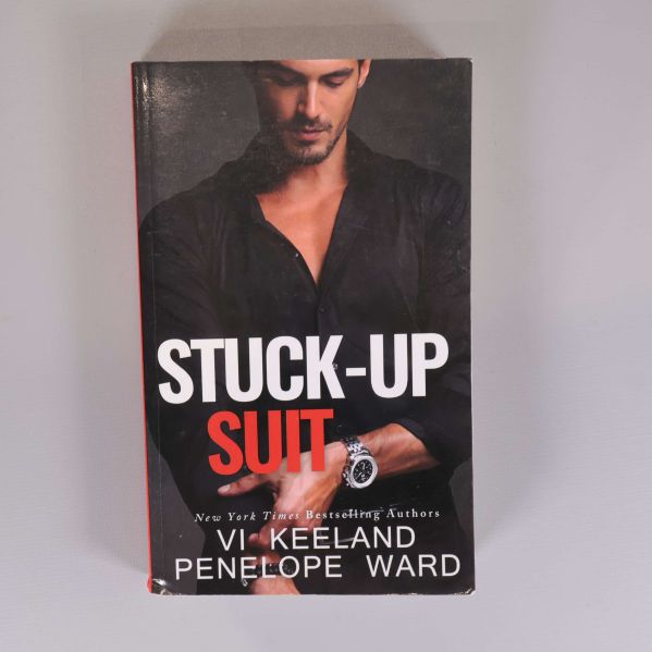 Framsidan av boken Stuck-up suit med svart omslag och röd text