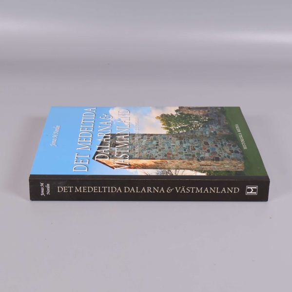 Bok liggande på sidan med text på ryggen Det medeltida Dalarna & Västmanland