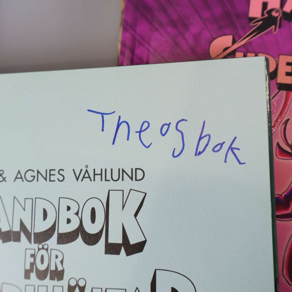Närbild på insida av bok med skriven text Theos bok