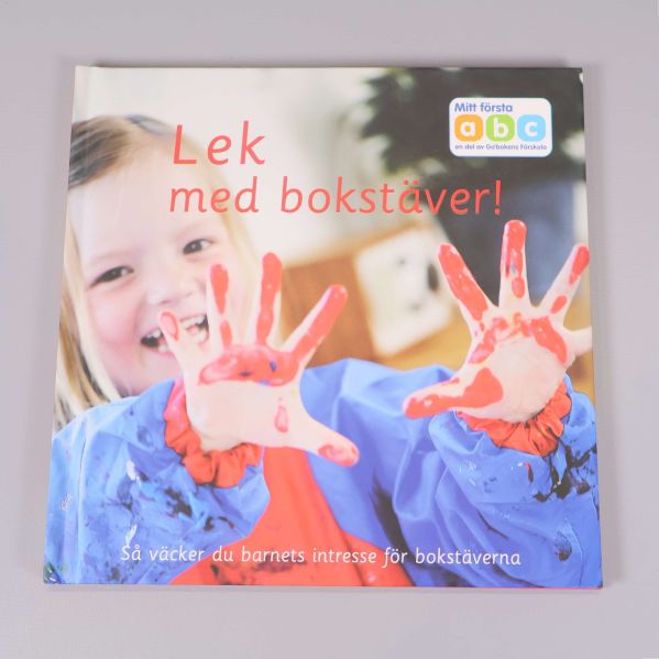 Framsidan av Lek med bokstäver med barn och färgglada händer