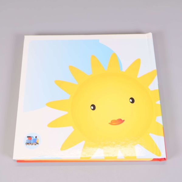Baksida av barnbok med illustration av sol och liten lokbild