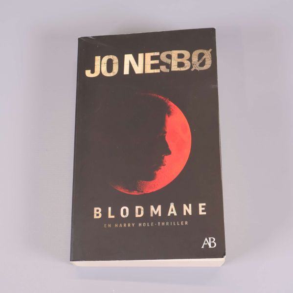Framsidan av boken Blodmåne av Jo Nesbø med siluett mot röd måne