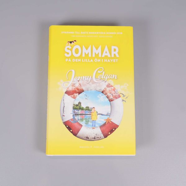 Framsidan av boken Sommar på den lilla ön i havet, med gul bakgrund och illustrerat omslag