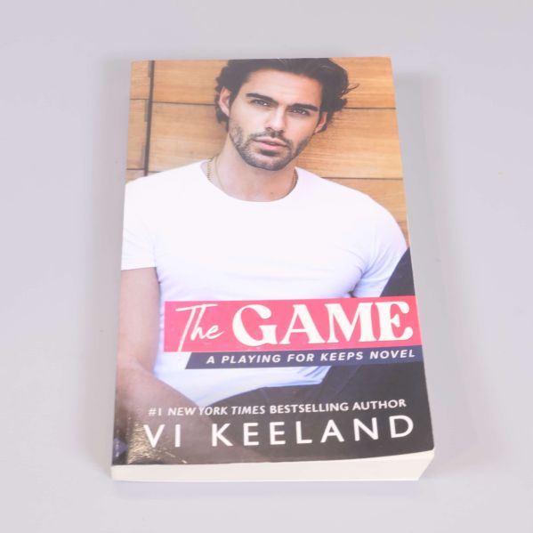 Framsida av pocketboken The Game av Vi Keeland med omslagsbild på person i vit t-shirt